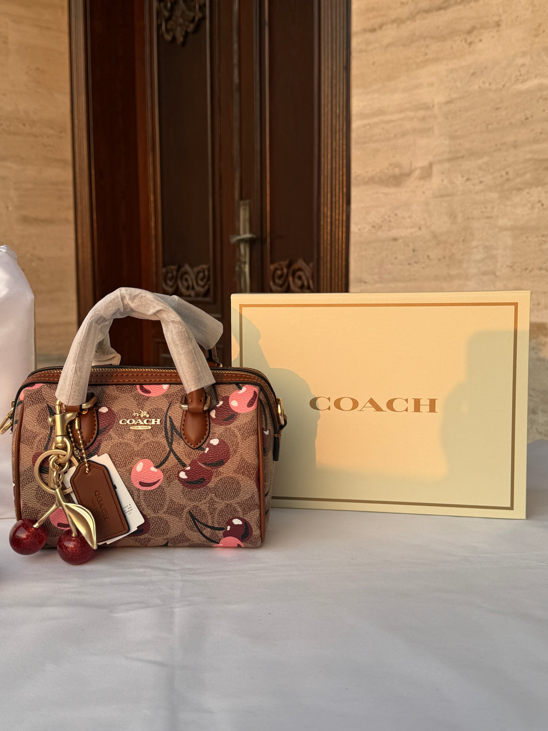 COACH LIGHT BROWN /TAN BASE CHERRY PATTERN BAG WITH CHERRY CHARM
